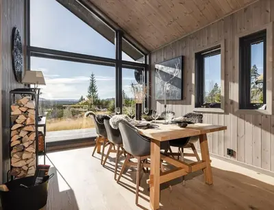 a dining room with a wooden table and chairs at Modern cabin with a Mountain View in Nos