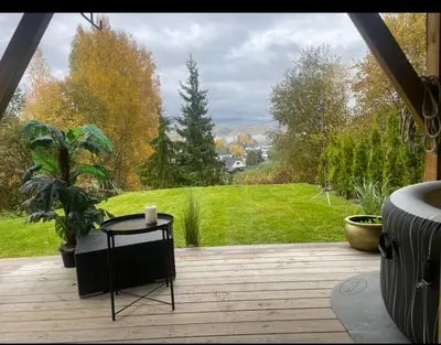 a wooden deck with a table and a view of a yard at Bingo apartaments in Hønefoss