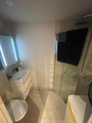 a bathroom with a toilet and a sink and a shower at Bingo apartaments in Hønefoss