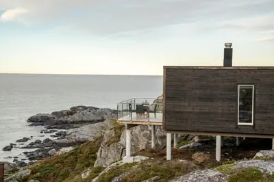 a house on a cliff next to the ocean at Runde Panorama - Castillo in Terøy