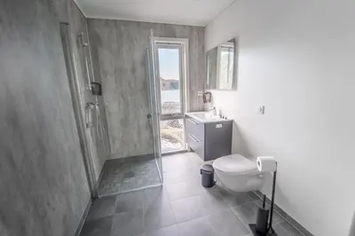 a bathroom with a shower and a toilet and a sink at Runde Panorama - Batavia Dream in Terøy