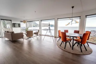a living room with a table and chairs and the ocean at Runde Panorama - Batavia Dream in Terøy