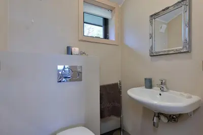 a bathroom with a sink and a toilet and a mirror at Modern Apartment with 3 Bedrooms and Stunning View in Beitostøl
