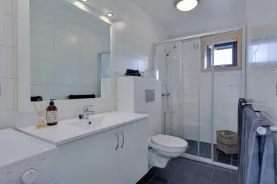 a white bathroom with a sink and a toilet at Modern Apartment with 3 Bedrooms and Stunning View in Beitostøl