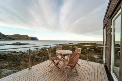 a wooden balcony with a table and two chairs on it at Runde Panorama - Blått Hav in Terøy