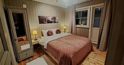 a bedroom with a large bed and two windows at Stallen in Heggem
