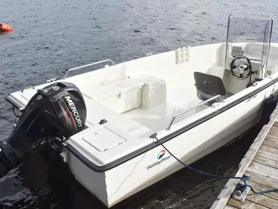 a white boat tied to a dock in the water at 6 person holiday home in HOSTELAND in Hosteland