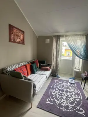 a living room with a couch and a window at Cozy room near city centre in Trondheim