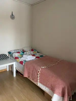 a bedroom with a bed with a blanket on it at Cozy room near city centre in Trondheim
