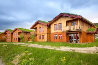 a large wooden house with a grass roof at Perfectly Located With Ski Access And Sauna in Beitostøl