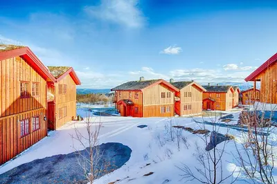 a row of wooden houses in the snow at Perfectly Located With Ski Access And Sauna in Beitostøl