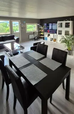 a black table and chairs in a living room at Rekkehus med 3 soverom in Trondheim