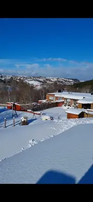 a snow covered yard with a building in the background at Rekkehus med 3 soverom in Trondheim