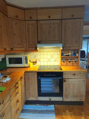 a kitchen with wooden cabinets and a microwave at Teglverket in Trondheim