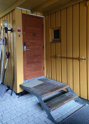 a wooden door with a bench in front of a house at Teglverket in Trondheim