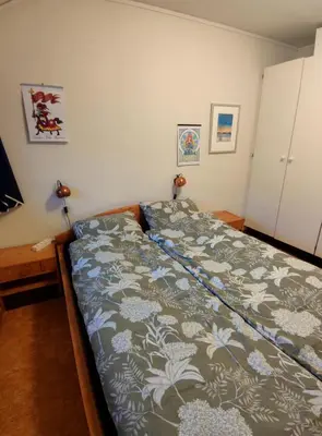 a bedroom with a bed with a blanket on it at Teglverket in Trondheim