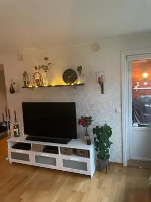 a living room with a television on a white entertainment center at Ski VM 2025 in Trondheim