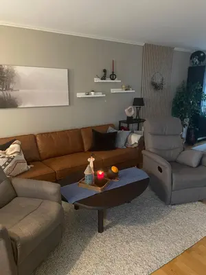 a living room with a couch and a chair and a table at Ski VM 2025 in Trondheim