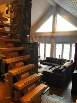 a living room with a couch and a stone wall at Hytta Kalven in Lunner