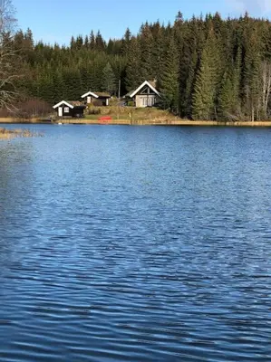 a large body of water with houses in the background at Hytta Kalven in Lunner