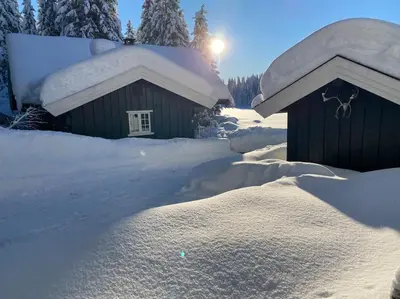 a house covered in snow with a pile of snow at Hytta Kalven in Lunner