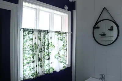 a bathroom with a window with a plant at Sjarmerende hus i sentrum in Elverum