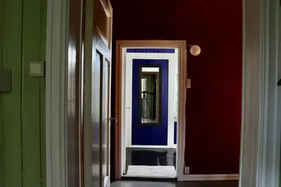 a hallway with a mirror and red and green walls at Sjarmerende hus i sentrum in Elverum