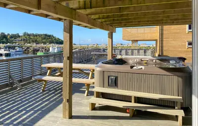 a grill on a deck with a table and benches at Beautiful Home In Fjørtoft With Wifi in Fjørtoft