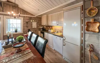 a kitchen with a table and a white refrigerator at Lovely Home In Beitostølen in Beitostøl