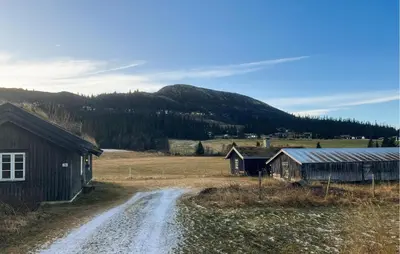 a dirt road next to two buildings and a mountain at Stunning Home In Fåvang With Wifi in Favang
