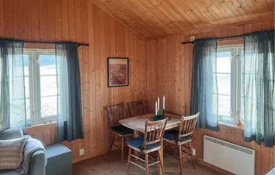 a dining room with a table and two windows at Stunning Home In Fåvang With Wifi in Favang