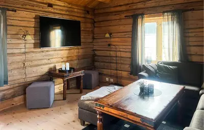 a living room with a couch and a table at Cozy Home In Fåvang With Wifi in Favang