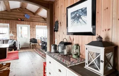 a kitchen with a stove in a room with wooden walls at Fantastisk Hytte På Lenningen in Etnedal