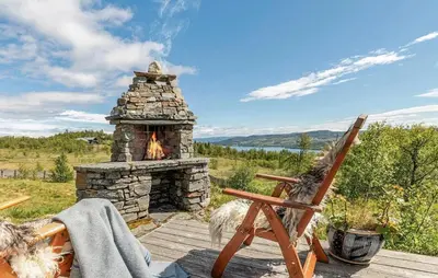 a stone fireplace on a deck with a rocking chair at 4 Bedroom Stunning Home In Hemsedal in Hemsedal
