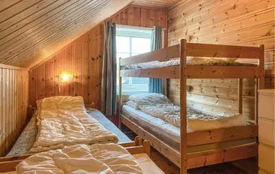 two bunk beds in a room with wooden walls at 2 Bedroom Beautiful Home In Frosta