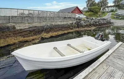 a white boat sitting on the water next to a dock at 2 Bedroom Beautiful Home In Frosta