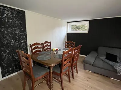 a dining room with a table and chairs and a couch at Apartments near Bergen Airport in Bergen