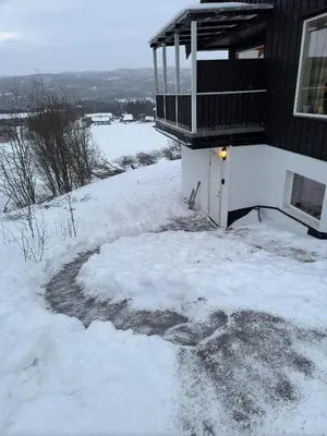 a yard covered in snow next to a house at Cozy apartment near ski attractions in Geilo
