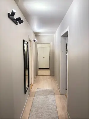 a hallway with white walls and a white door with a mirror at Cozy apartment near ski attractions in Geilo