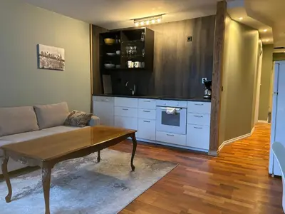 a living room with a couch and a kitchen at Retro Apartment in Bergen