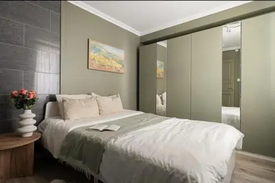 a bedroom with a large bed and a mirror at Leilighet i Sandviken in Bergen
