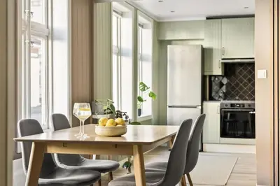 a kitchen with a table with chairs and a glass of wine at Leilighet i Sandviken in Bergen