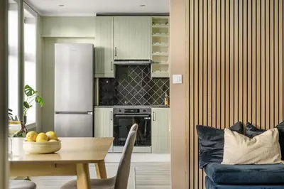 a kitchen with a table and a blue couch at Leilighet i Sandviken in Bergen