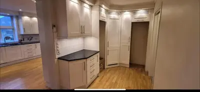 a kitchen with white cabinets and a black counter top at Odda Central Apartment in Odda