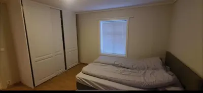 a small bedroom with a bed and a window at Odda Central Apartment in Odda