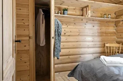 a room with a wooden wall with a bed and a door at Cabin With Panoramic Views Over Trysil in Trysil