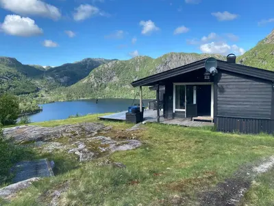 a cabin with a view of a lake and mountains at Mountain Cabin With Magical View And Tranquil Lake in Matre