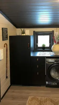 a kitchen with a black refrigerator and a window at Mountain Cabin With Magical View And Tranquil Lake in Matre