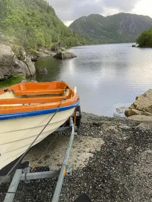 a boat sitting on the shore of a lake at Mountain Cabin With Magical View And Tranquil Lake in Matre