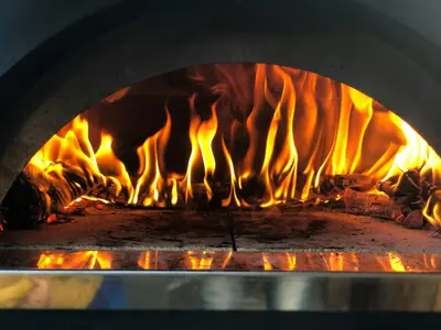 a fire burning in a brick oven with flames at Countryside Cabin With Jacuzzi Near Stryn in Sølberg